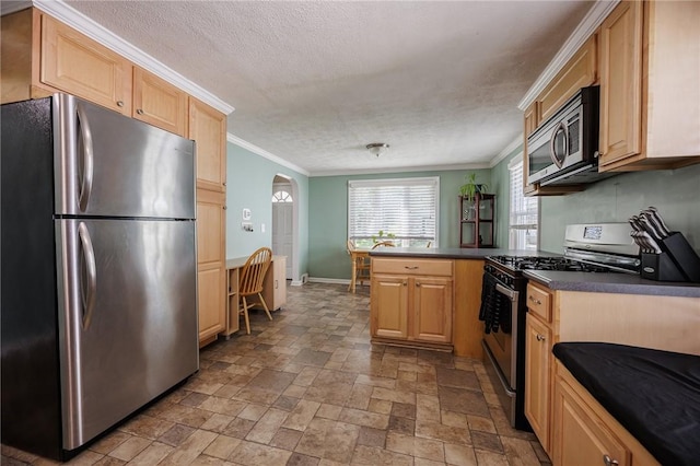 kitchen with light brown cabinetry, stainless steel appliances, a peninsula, ornamental molding, and stone tile flooring