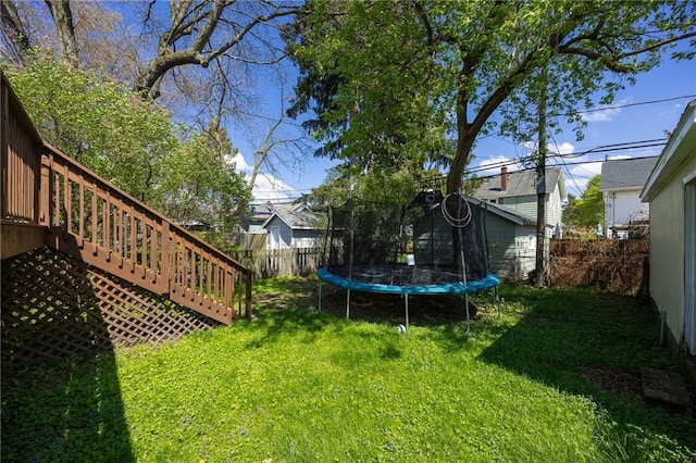 view of yard featuring a fenced backyard, a trampoline, and stairway