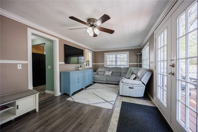 living room featuring crown molding, a ceiling fan, baseboards, and dark wood-style floors