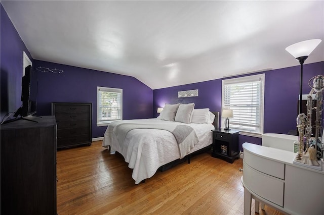 bedroom featuring lofted ceiling and light wood-type flooring