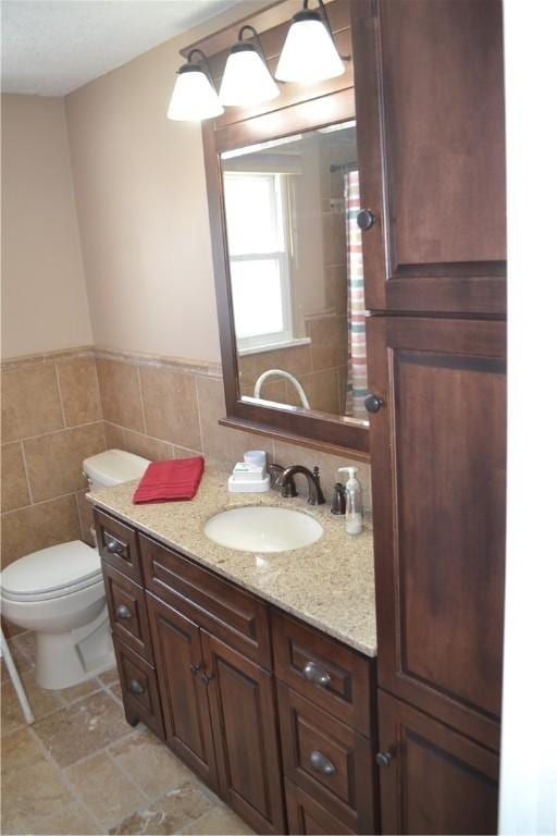 86 Everwild Ln, Greece, NY 14616 - bathroom featuring toilet, tile walls, a wainscoted wall, and vanity