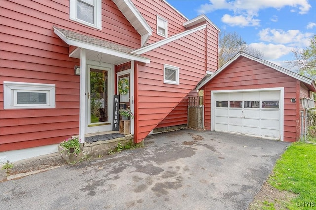 view of property exterior with an outbuilding, driveway, and a detached garage