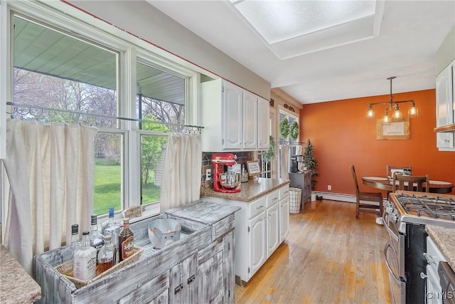 kitchen featuring light countertops, white cabinetry, gas stove, and light wood-type flooring