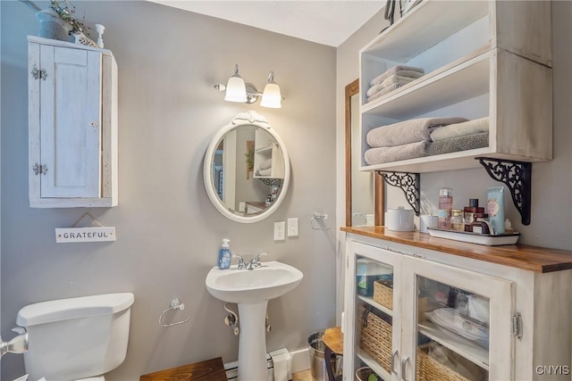bathroom with a baseboard heating unit and toilet