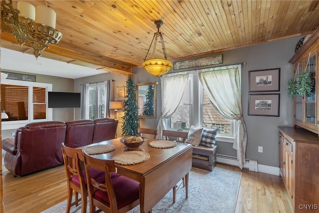 dining space with baseboards, plenty of natural light, baseboard heating, and light wood-style flooring
