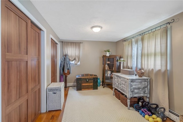 interior space featuring multiple closets and a baseboard heating unit