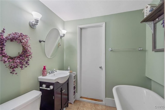bathroom featuring toilet, a freestanding tub, and vanity