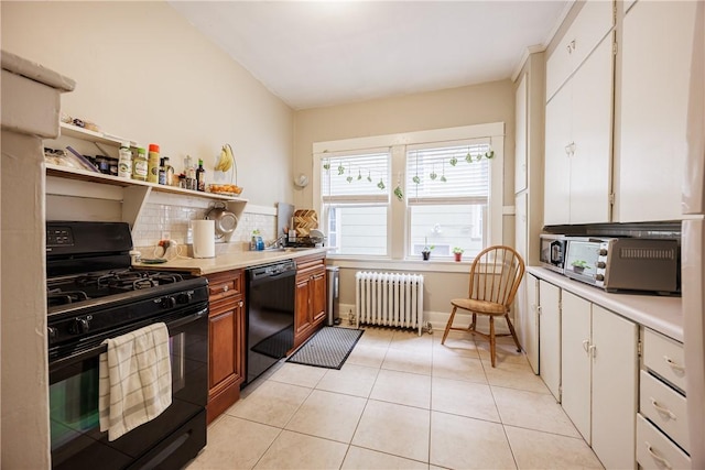 kitchen featuring decorative backsplash, light countertops, light tile patterned floors, black appliances, and radiator