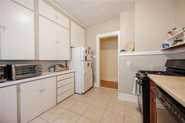 kitchen with light countertops, stainless steel dishwasher, freestanding refrigerator, and black gas range