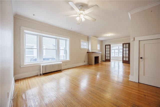 unfurnished living room featuring radiator, baseboards, ornamental molding, and light wood-type flooring
