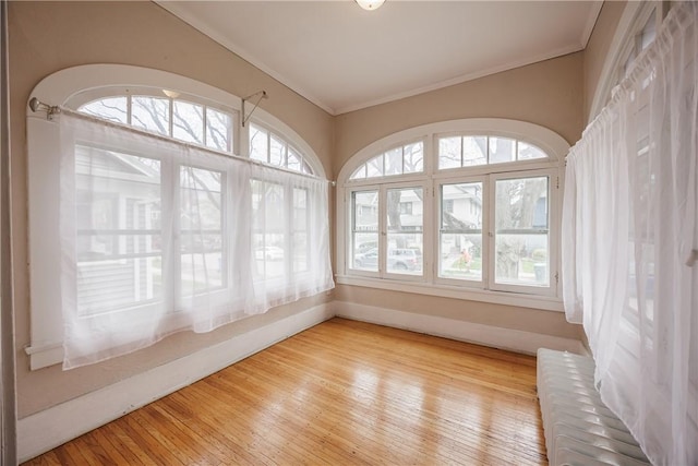 empty room featuring ornamental molding, radiator heating unit, and hardwood / wood-style floors