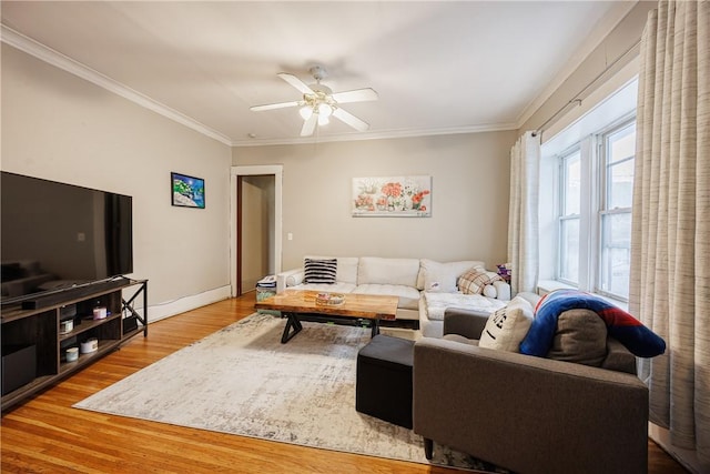 living area featuring crown molding, a ceiling fan, baseboards, and wood finished floors