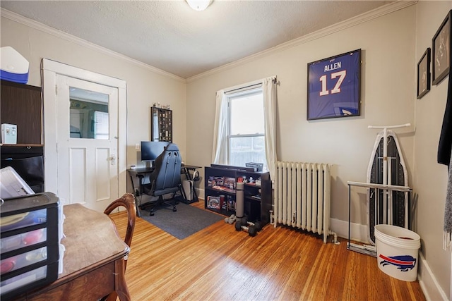 home office featuring radiator heating unit, baseboards, ornamental molding, and wood finished floors