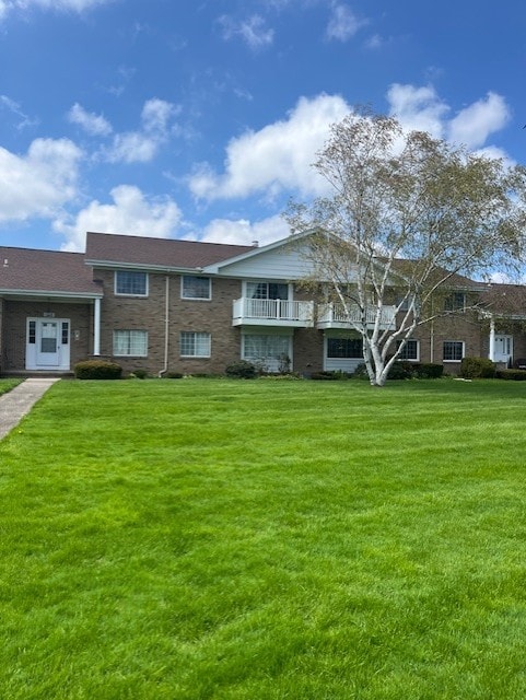 view of front of house with brick siding and a front yard
