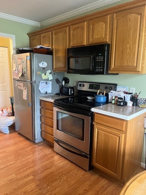 kitchen with crown molding, light wood-type flooring, light countertops, brown cabinets, and stainless steel appliances