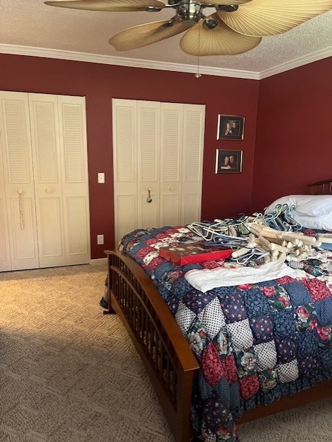 bedroom with crown molding, two closets, and light carpet