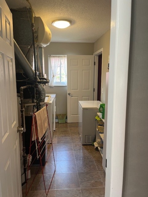 washroom featuring laundry area, a textured ceiling, and washer and dryer