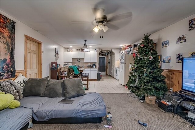 25082 Ridge Rd, Watertown-Town, NY 13601 - living area with a ceiling fan, visible vents, wainscoting, wood walls, and light carpet