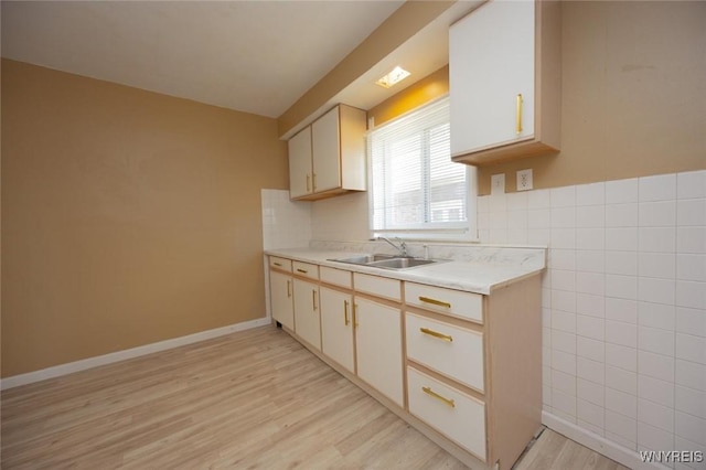 1126 La Salle Ave, Niagara Falls, NY 14301 - kitchen featuring light countertops, tile walls, a sink, and light wood-type flooring