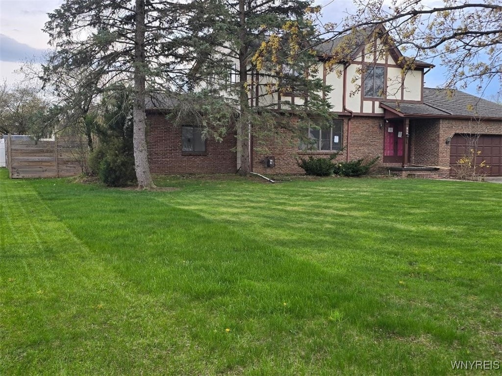 850 Willow St, Lockport-City, NY 14094 - view of yard with an attached garage and fence