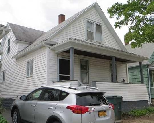 bungalow-style home featuring a chimney and a porch