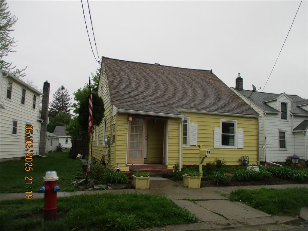 cape cod house featuring roof with shingles and a chimney