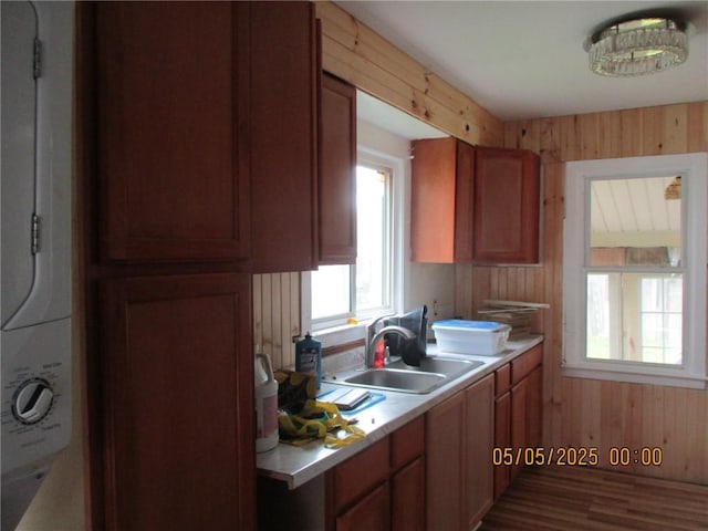 26 Balcom Ave, Corning, NY 14830 - kitchen featuring wooden walls, a sink, light countertops, light wood finished floors, and brown cabinets