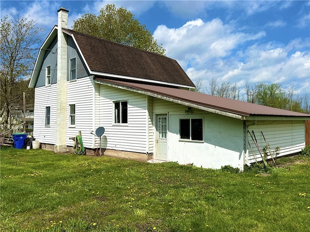 rear view of house featuring a lawn and a chimney