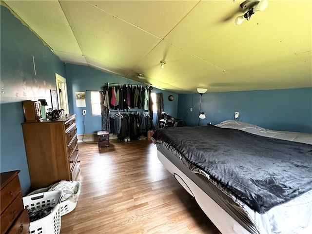 bedroom featuring wood finished floors and vaulted ceiling