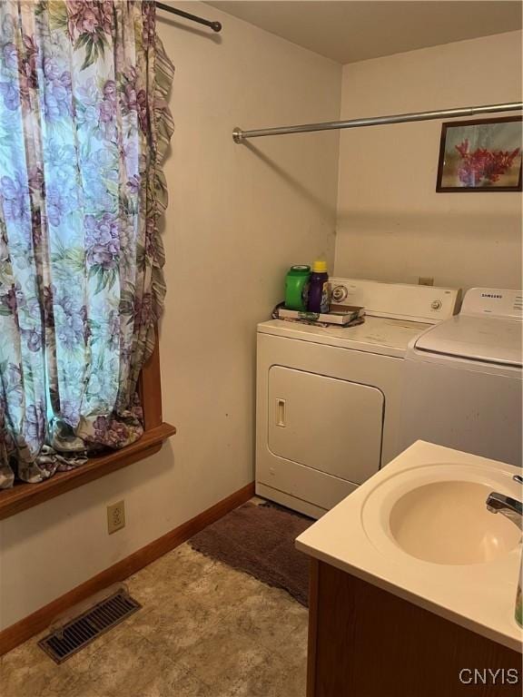 laundry area with laundry area, a sink, baseboards, visible vents, and washing machine and dryer