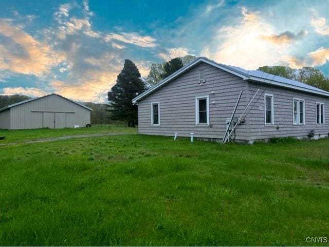 back of property at dusk featuring a lawn