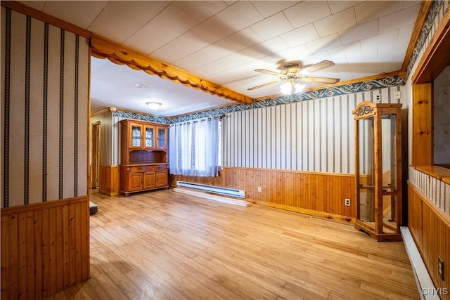11511 State Route 26, Ava, NY 13303 - empty room featuring light wood-type flooring, a baseboard radiator, wainscoting, and wallpapered walls