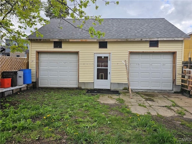 detached garage featuring fence