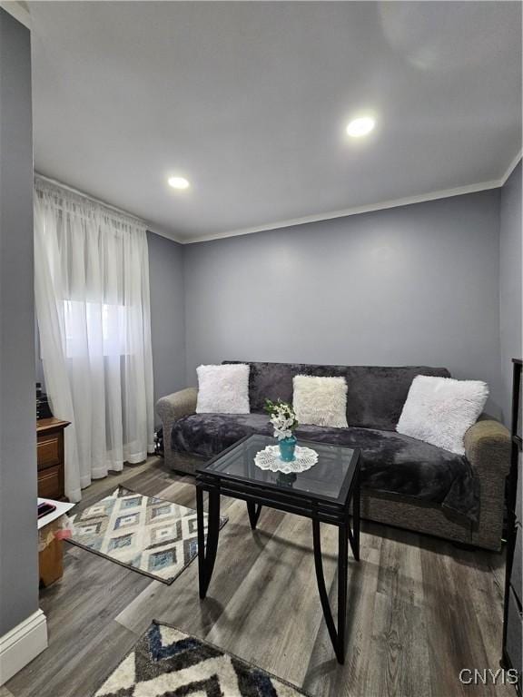 living room with baseboards, ornamental molding, recessed lighting, and wood finished floors