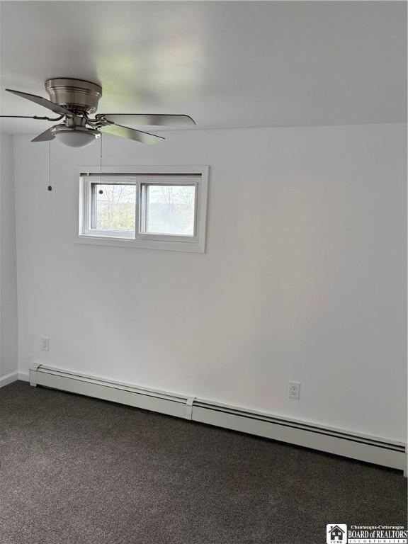 carpeted empty room featuring baseboards, ceiling fan, and a baseboard heating unit