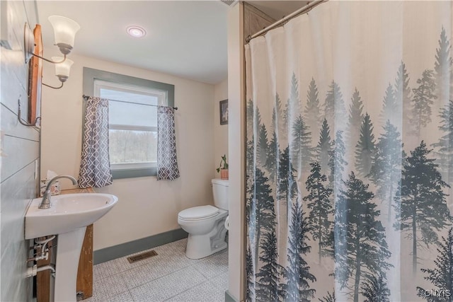 full bathroom with toilet, tile patterned floors, a shower with shower curtain, baseboards, and visible vents