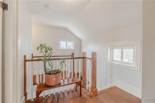 additional living space featuring baseboards, wood finished floors, and vaulted ceiling