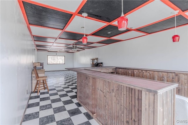 bar with pendant lighting, ceiling fan, dark floors, a dry bar, and coffered ceiling