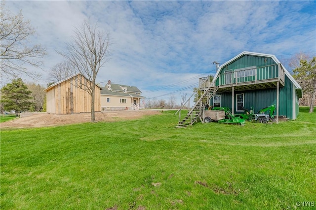 view of yard with stairs, an outbuilding, and a deck