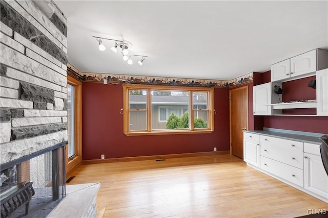 unfurnished living room featuring light wood-style floors, visible vents, and a fireplace