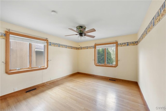 unfurnished room featuring light wood-style floors, baseboards, ceiling fan, and visible vents
