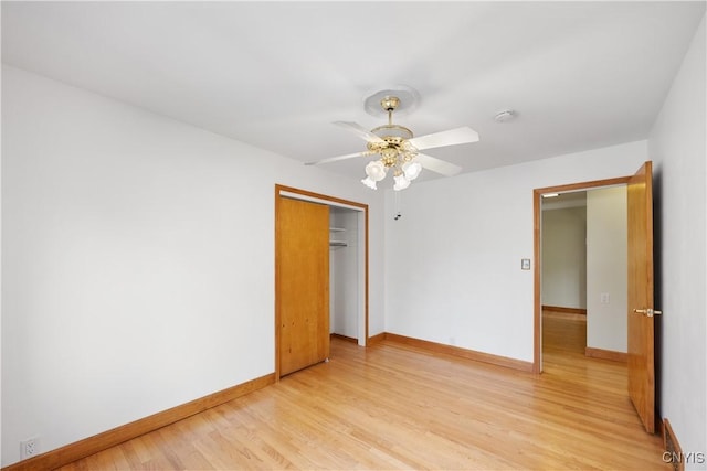 unfurnished bedroom with a closet, baseboards, ceiling fan, and light wood-style floors