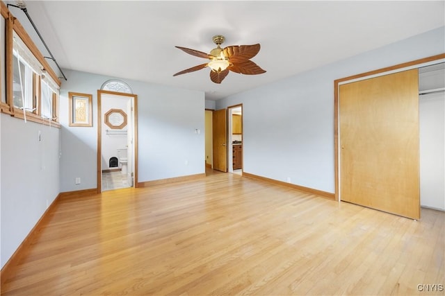 unfurnished living room with light wood-style floors, baseboards, and ceiling fan