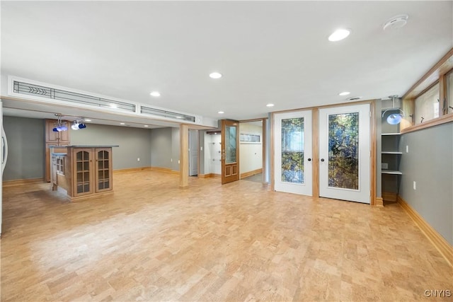 interior space with baseboards, recessed lighting, light wood finished floors, and french doors