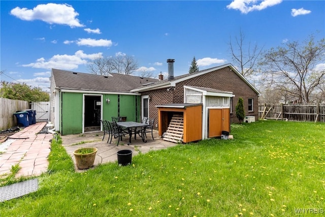 rear view of house featuring a fenced backyard, a gate, a patio, and a yard