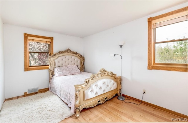 bedroom with visible vents, baseboards, and light wood-type flooring