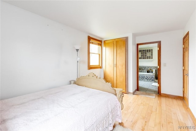 bedroom with a closet, baseboards, and light wood-style floors