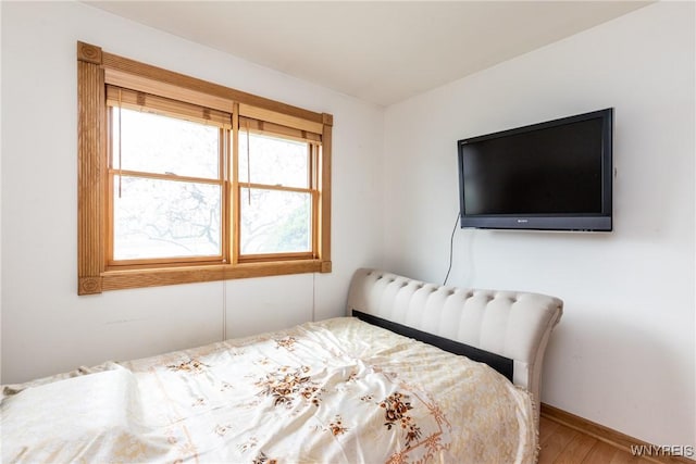 bedroom featuring baseboards and wood finished floors