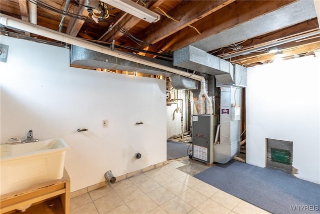 unfinished basement with heating unit, tile patterned floors, and a sink