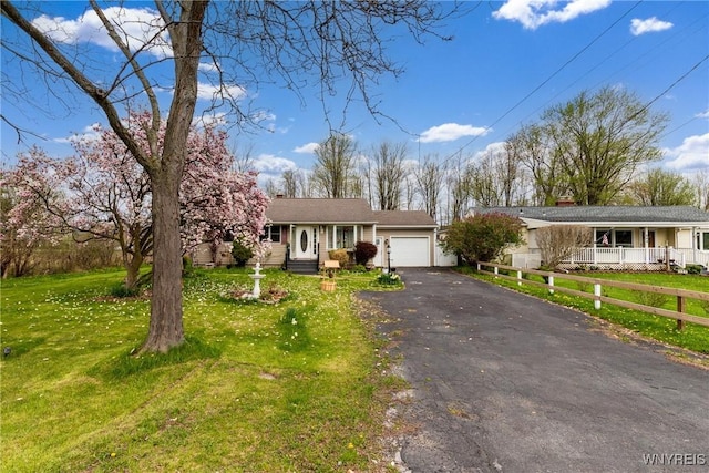 ranch-style house with a garage, a chimney, driveway, and a front yard